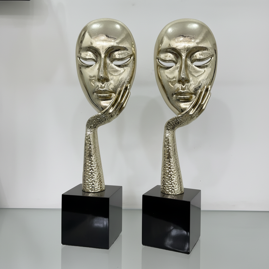 Gold face mask sculpture pair three quarter view